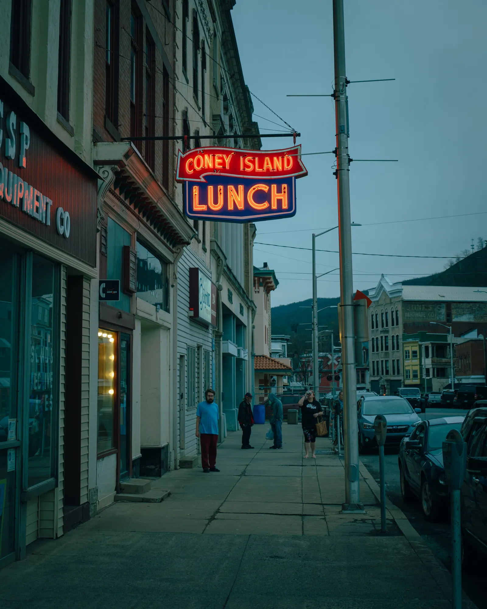 A neon Coney Island Lunch sign over a small-town sidewalk at dusk, by Jon Bilous